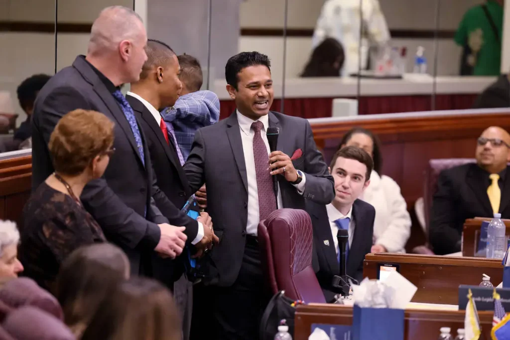 Assemblymember Reuben D’Silva holds microphone in Legislative Building.