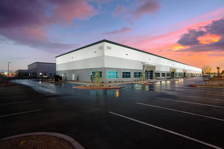 Modern industrial commercial building at sunset, wet pavement