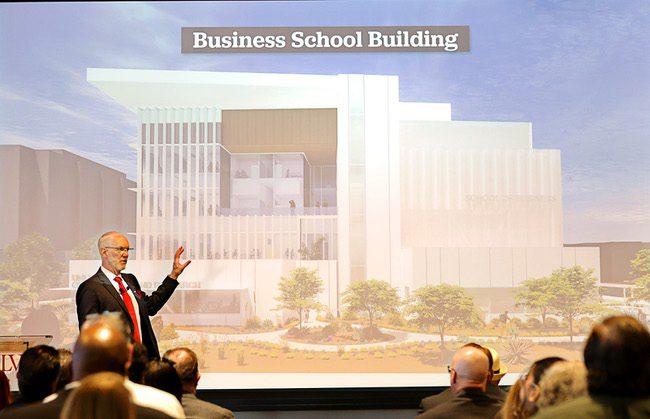 UNLV Interim President Chris Heavy at State of the University address in April, pointing at a rendering of the new UNLV business building.