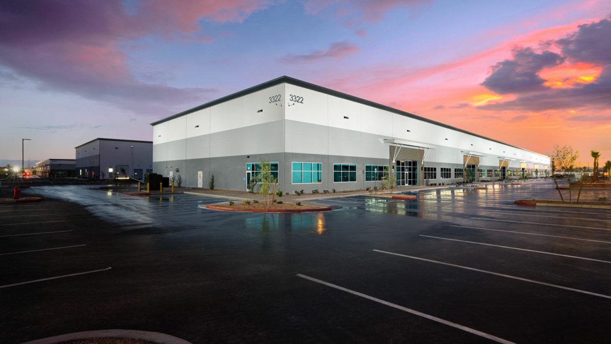 Modern industrial commercial building at sunset, wet pavement