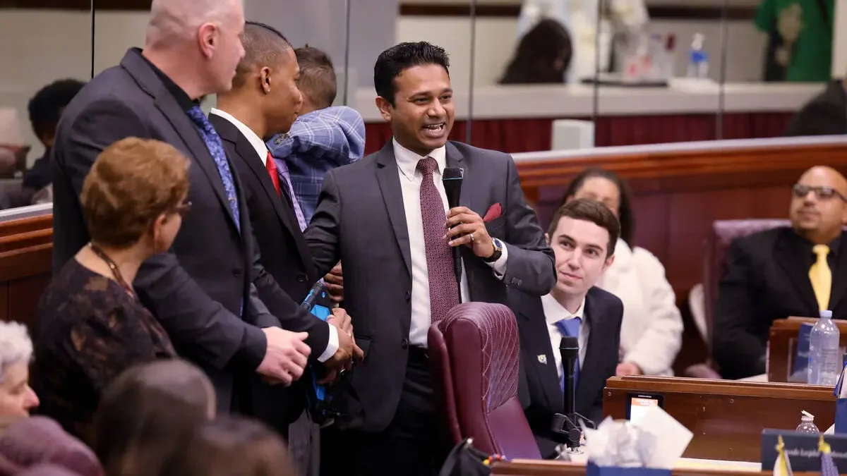 Assemblymember Reuben D’Silva holds microphone in Legislative Building.